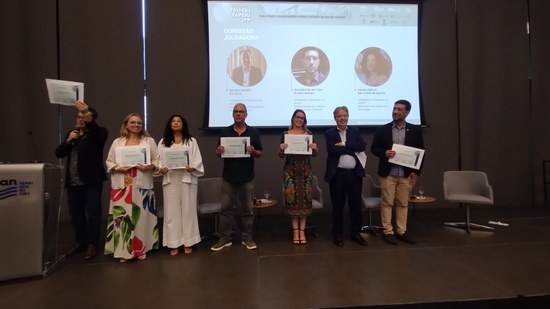 Membros da comissão julgadora recebem homenagens, com o professor André Gardel, da UNIRIO, ao centro (Foto: Comso)
