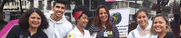 grupo de três professores e 3 estudantes sorrindo e olhando para a frente, em um evento científico