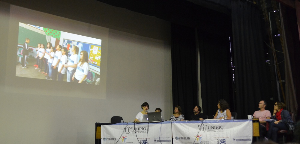 Coordenadora do subprojeto de Música apresenta oficina realizada em escola (Foto: Comso)