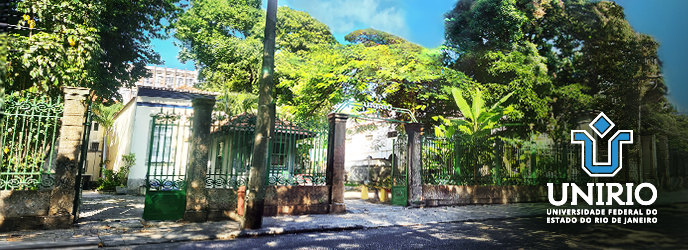 Fachada histórica do campus da Reitoria da UNIRIO na Urca, mostrando o portão de ferro aberto e o jardim arborizado sob luz solar. À direita, a marca gráfica da universidade.
